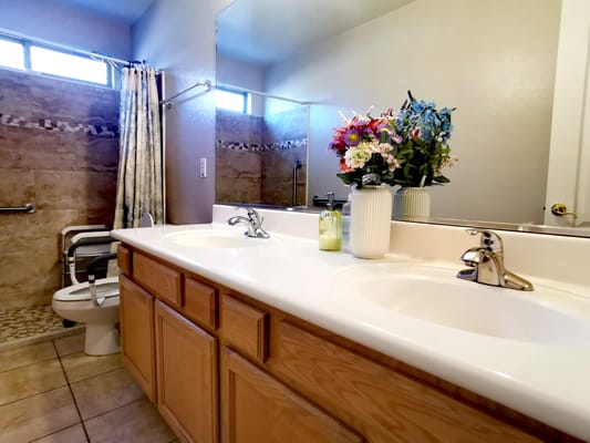 Bright and clean bathroom with flower arrangement and accessible features