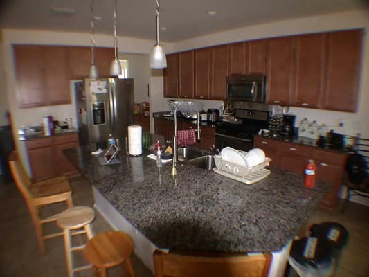 Interior view of a kitchen with a large island and wooden cabinets
