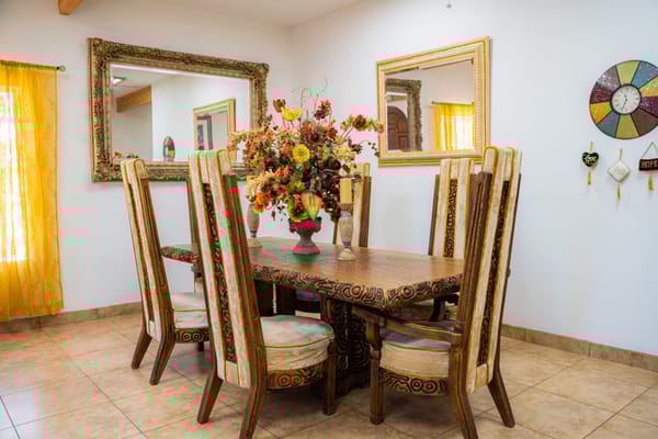 Dining table with decorative flower arrangement and ornate mirrors