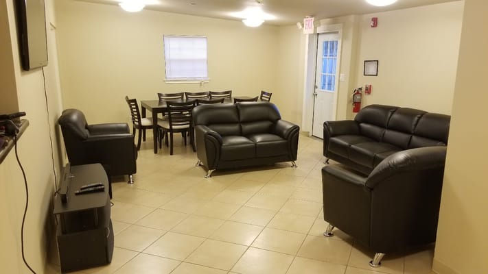 Cozy living room with black leather sofas and dining area