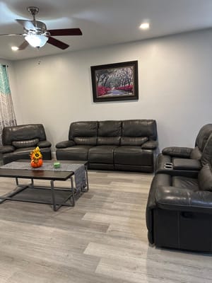 Spacious living room with leather couches and decorative artwork.