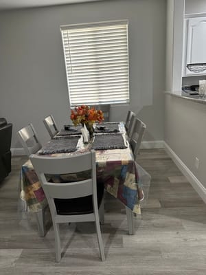 Dining table set for a meal with flowers in a well-lit room