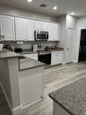 Bright kitchen with white cabinetry and stainless steel appliances