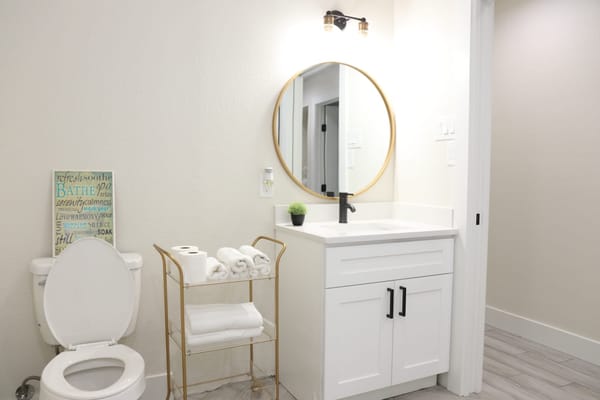 Modern bathroom with a toilet, sink, and decor.