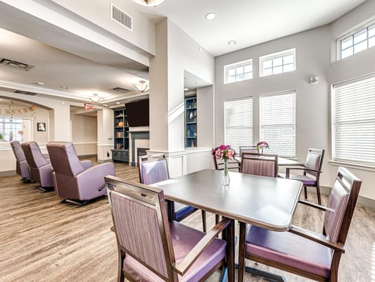 Cozy common area with chairs and tables at Iris Memory Care