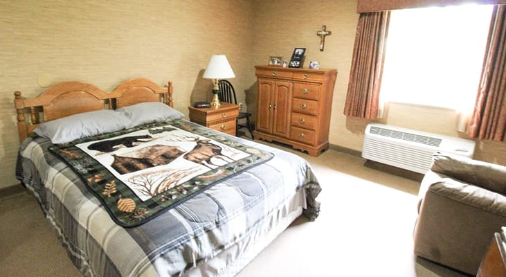 Cozy resident room with a quilt and wooden furniture