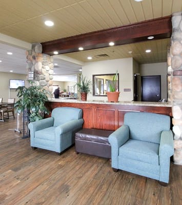 A cozy common area with blue chairs and wood accents
