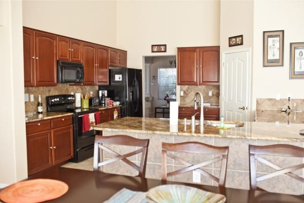 Bright kitchen area with wooden cabinets and granite countertops