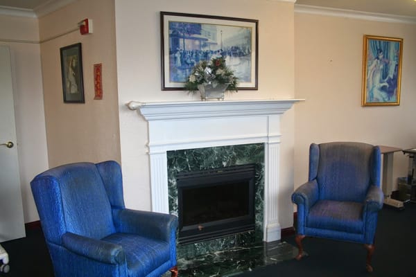 Cozy lounge area with blue chairs and a fireplace