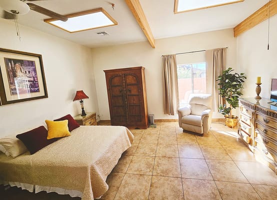 Bright and airy senior living bedroom with a bed and armchair