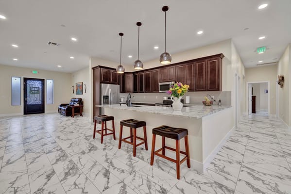 Spacious kitchen area with marble flooring and a granite countertop