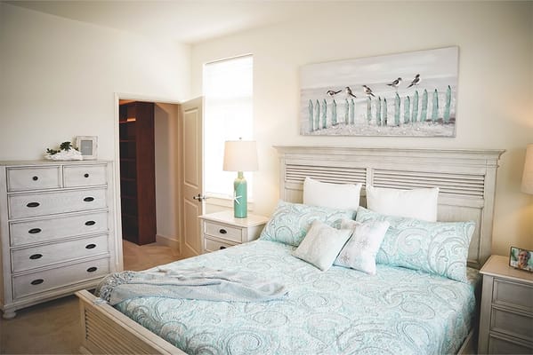 Well-decorated bedroom with quilt and artwork