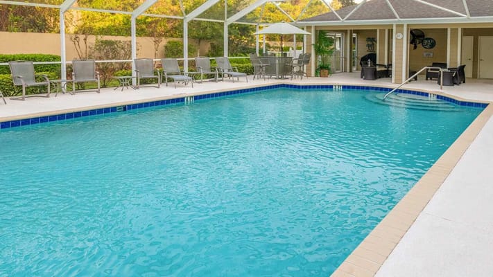 View of the outdoor swimming pool with lounge chairs and table