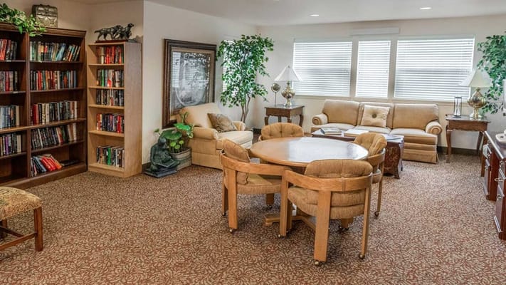 A comfortable common area with bookshelves, seating, and natural light.