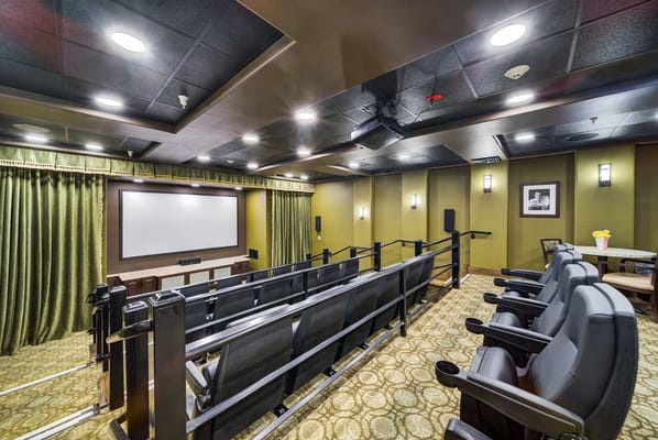 Theater room with seating and a large screen