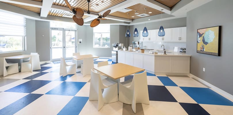 Bright common area with tables and kitchen space