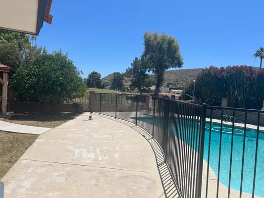 Outdoor patio area with a pool and fencing