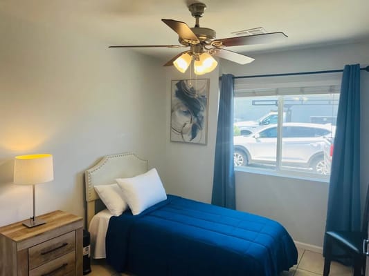 Cozy private room with a blue bedspread and window