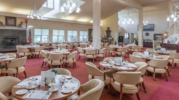 Spacious dining room withround tables and plush seating
