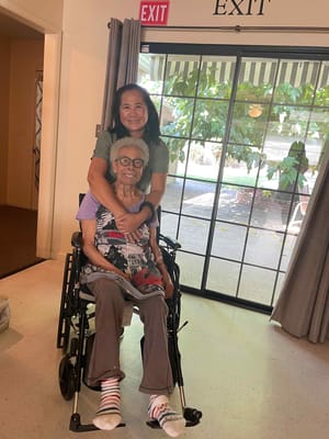 Staff member hugging a resident in a warm interior setting