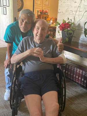 Caregiver and resident smiling in a common area