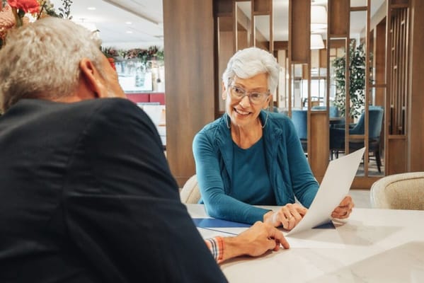 Older adult engaging in conversation with staff in a common area