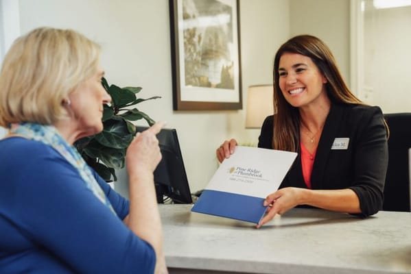 Reception area with staff assisting a resident