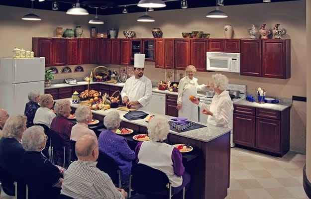 Residents participating in a cooking class in the kitchen