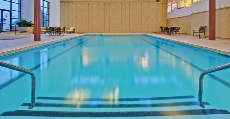 Indoor swimming pool area with clear water and seating