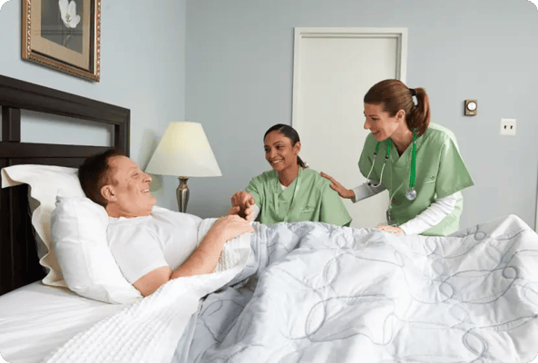 Healthcare staff interacting with a resident in a room