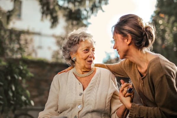 A resident enjoying a conversation with staff outdoors