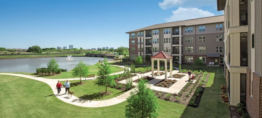 Residents walking in landscaped outdoor area by the lake