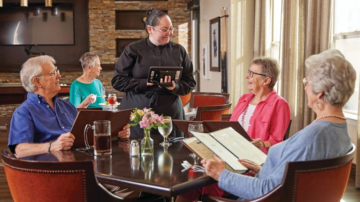 Residents enjoying meals in a dining room setting