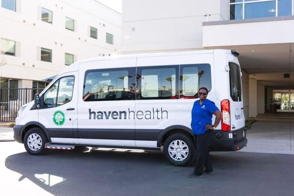 A staff member next to a facility transport van
