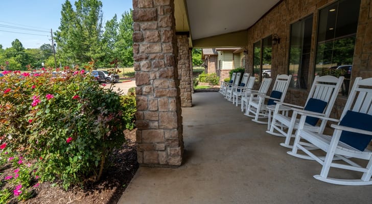 Outdoor rocking chairs on the porch among flowers