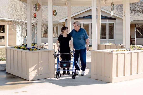 Residents walking in a garden area with flowers