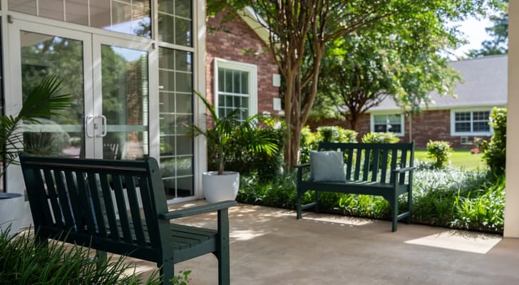 Outdoor seating area with benches and greenery