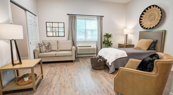 A comfortable resident room with a bed and seating