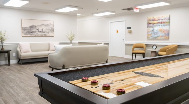 Interior view of a common area with seating and shuffleboard