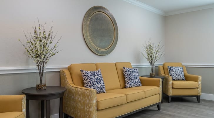 Interior lounge area with yellow furniture and decorative plants