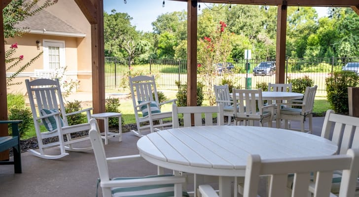 Covered outdoor seating area with rockers and tables