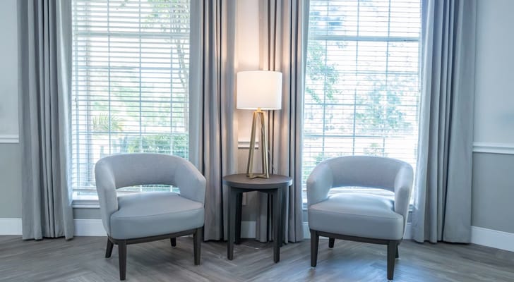Two chairs beside a lamp in a well-lit room