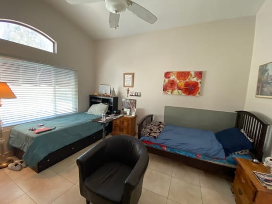 A twin room setup with two beds and a chair