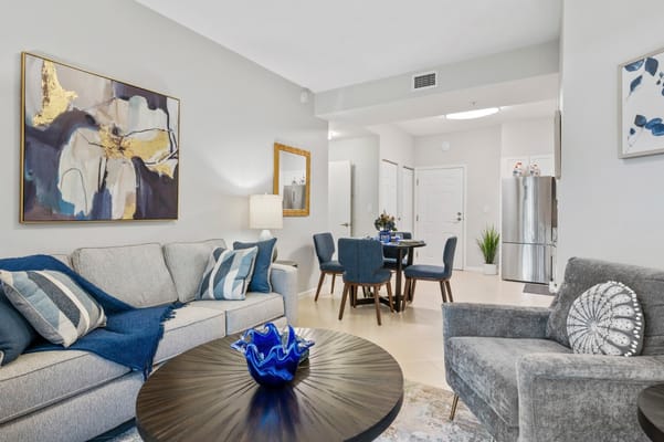 Living room interior with grey sofa and dining area