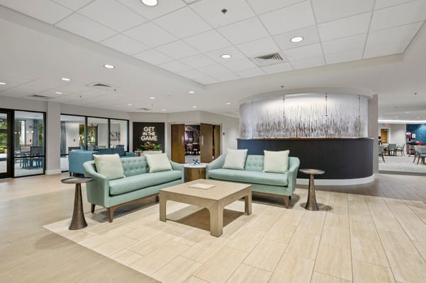 Quiet lobby area with blue-green couches and a coffee table