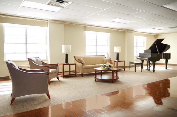 Bright lounge area with seating and a piano