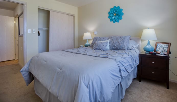 Comfortable bedroom with blue bedding and nightstand