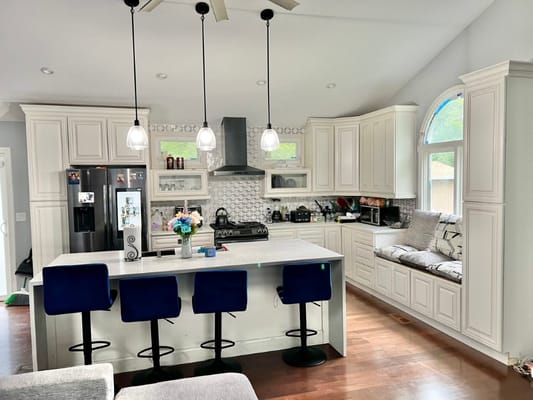 Spacious kitchen with white cabinets and island seating