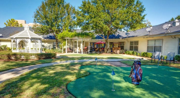 A putting green with flags and a golf bag in the courtyard of The Auberge at Kingwood.