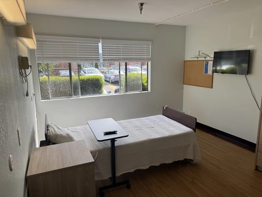 Interior view of a resident room with a bed and TV